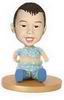 Cute little boy bobblehead sitting on the floor playing