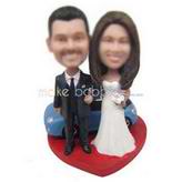Groom in black suit and bride in white wedding dress with their blue car custom bobbleheads