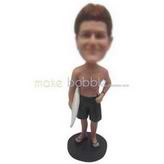 Man in black shorts handing up with a surfboard custom bobbleheads 