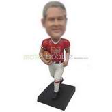 Man in red sports T-shirt holding a football custom bobbleheads