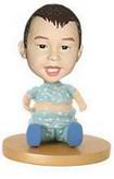 Cute little boy bobblehead sitting on the floor playing