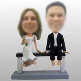 Couple bobble head doll Sitting On a Bench