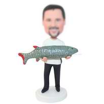 homme en T-shirt blanc tenant un grand figurines personnalisées de poissons